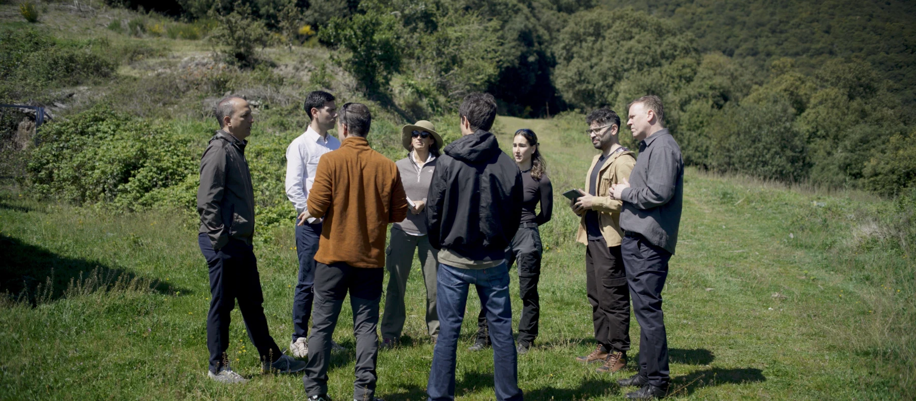 Grupo de trabajo de EMFF conversando en un prado de montaña.